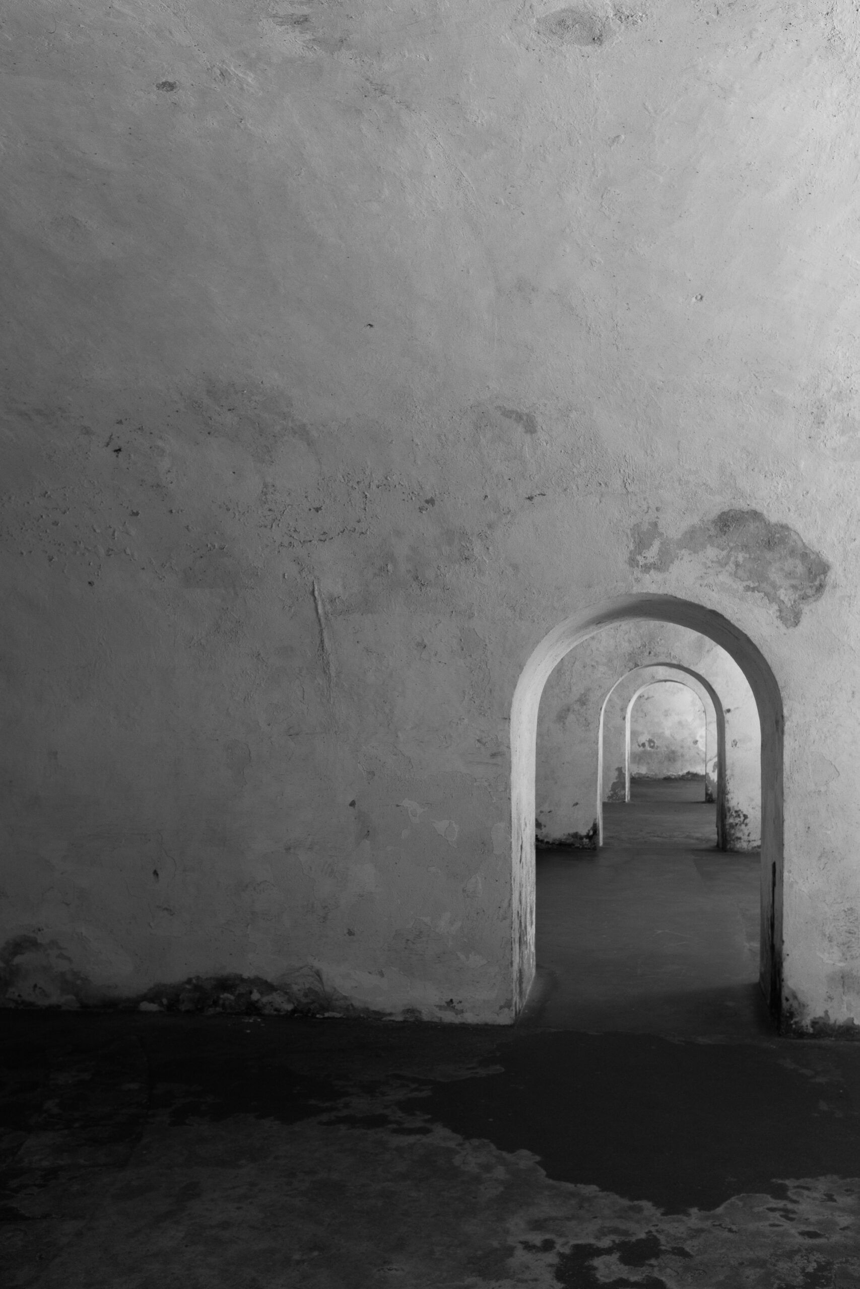 Black and white image of arched corridors in Castillo San Felipe del Morro.