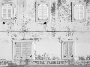 Aged building facade in Zadar with rustic shutters