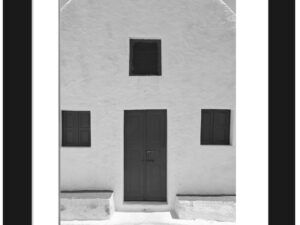 Simple white house in Santorini with symmetric windows and a minimalist design.